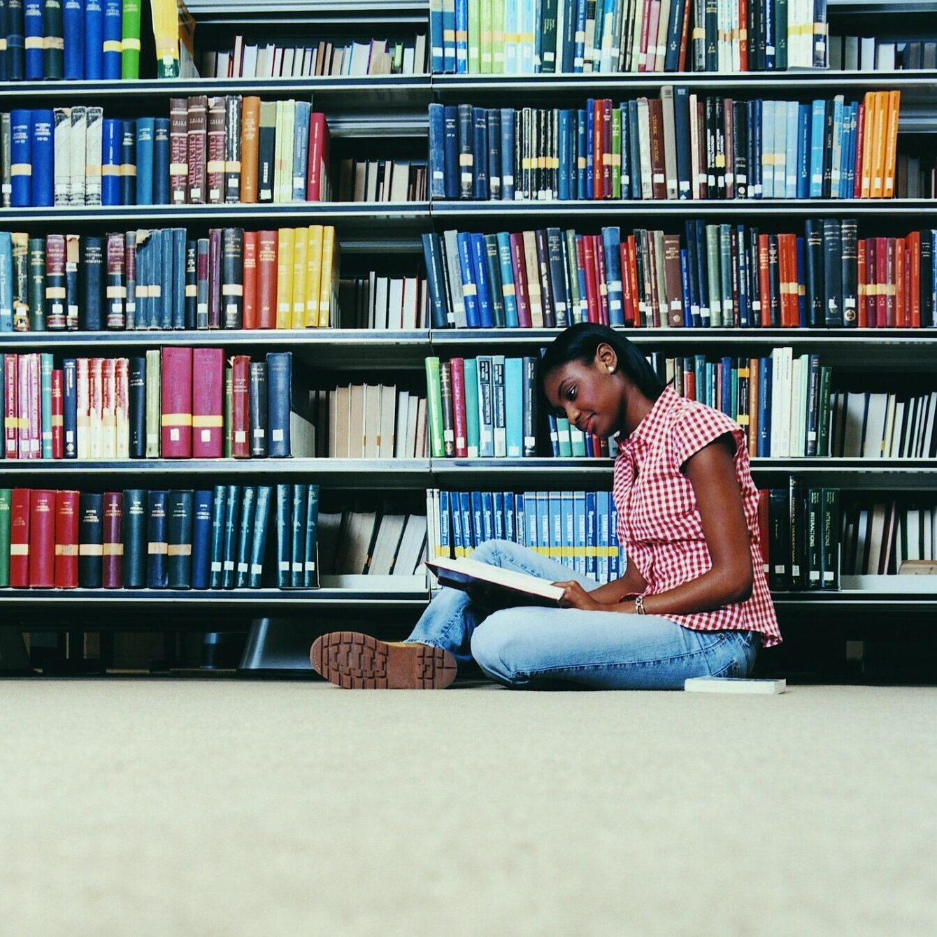 A girl reading a book in a library